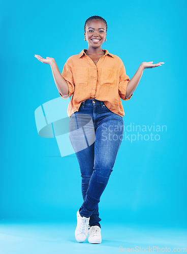 Image of Portrait, showing and black woman with promotion, smile or opportunity on a blue studio background. Person, girl or model with happiness, decision or choice with presentation, discount deal or option