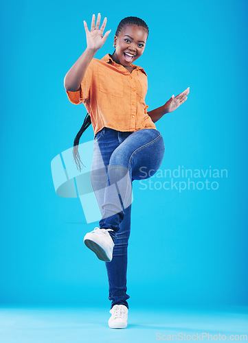 Image of Woman, excited and leg up to celebrate in studio for achievement, promotion or sale deal. Portrait of African person on a blue background for happiness, winning and good news or fashion announcement