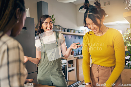 Image of Conversation, bonding and girl friends in the kitchen of their new apartment having fun together. Happy, smile and group of young women talking and cooking a meal for lunch or dinner in a modern home