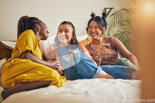 Image of Friends, conversation and women with drink in home for relaxing, bonding and talking together. Friendship, happy and group of people laughing for relationship, visit and chat on sofa in living room