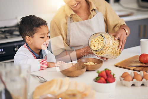 Image of Breakfast, smile and food help with family and cooking with morning cereal at a home. Kitchen, love and happy support of a mother and young child with teaching and care for baking learning together