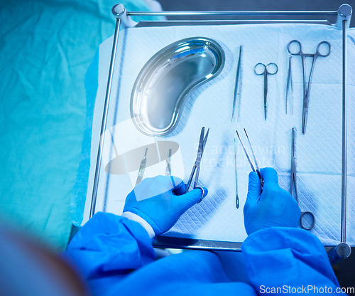 Image of Surgery, nurse and table with tools in hospital, operation room and medical equipment with scalpel, scissors and bowl. Surgeon, hands and above doctor ready with medicine or tool for procedure