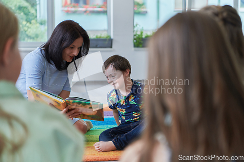 Image of Reading time in an elementary school or kindergarten, a teacher reading a book to children in an elementary school or kindergarten. The concept of pre-school education. Selective focus