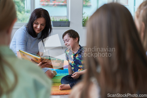 Image of Reading time in an elementary school or kindergarten, a teacher reading a book to children in an elementary school or kindergarten. The concept of pre-school education. Selective focus