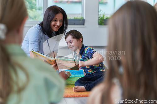 Image of Reading time in an elementary school or kindergarten, a teacher reading a book to children in an elementary school or kindergarten. The concept of pre-school education. Selective focus