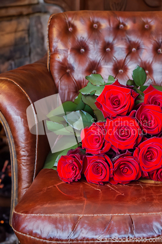 Image of Bouquet Of Red Roses On An Old Leather Armchair