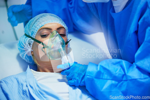 Image of Surgery, anesthesia and doctor with woman with oxygen mask for medical service, operation and procedure. Healthcare, hospital and surgeons with gas, breathing and ventilation equipment for patient