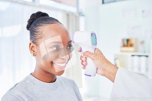 Image of Black woman, doctor and infrared thermometer for temperature, fever or checkup at the hospital. Happy African female person or patient smile in screening, visit or regulation for health and safety