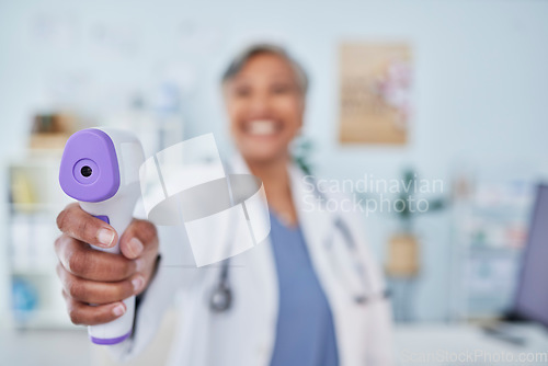 Image of Happy woman, doctor and infrared thermometer in checking temperature or fever at hospital. Closeup of female person, medical or healthcare professional with laser scanner for flu screening at clinic
