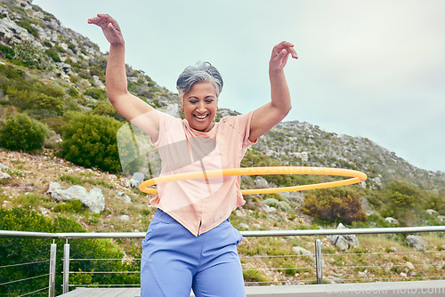 Image of Senior woman, hoop and fitness outdoor with smile, training and playful on balcony, mountains and healthy. Mature lady, exercise and happy for wellness, stomach workout and toys on rooftop in Hawaii