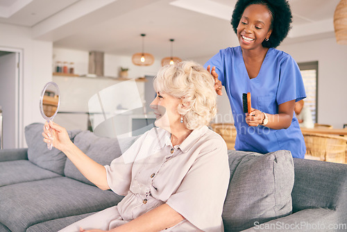 Image of Caregiver brush hair of senior woman in the living room of the modern retirement home for self care. Mirror, routine and African female nurse doing a hairstyle for an elderly patient in the lounge.