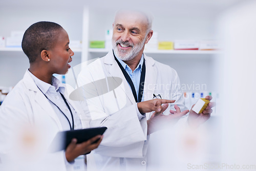 Image of Conversation, tablet and pharmacists checking medication for inventory, stock or medical research. Healthcare, medicine and senior chemist mentor teaching female pharmaceutical student with tech.