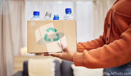 Image of Plastic, recycle and hands with bottle in box in living room for eco friendly, reuse and renewable litter. Sustainability, conservation and person with container to reduce waste, litter and garbage