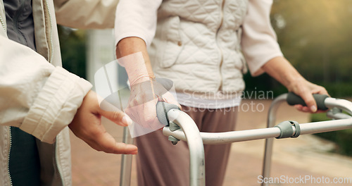 Image of Hands, support and senior person with a walker for injury rehabilitation, walking help and physiotherapy. Healthcare, patient with a disability and gear for nursing in retirement with a caregiver