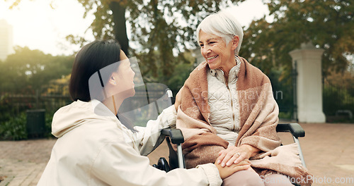 Image of Wheelchair, park and a senior woman with a disability talking to her nurse during a walk together outdoor. Healthcare, medical and a female care chatting to an elderly patient or resident in a garden