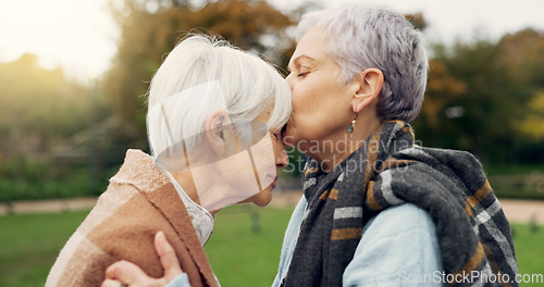 Image of Senior woman kissing her friend on the forehead for affection, romance and bonding on outdoor date. Nature, commitment and elderly female couple in retirement with intimate moment in garden or park.