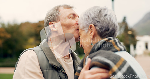 Image of Kiss, forehead and senior couple in a park with love, happy and conversation with romantic bonding. Kissing, old people and elderly man embrace woman with care, romance or soulmate connection outdoor