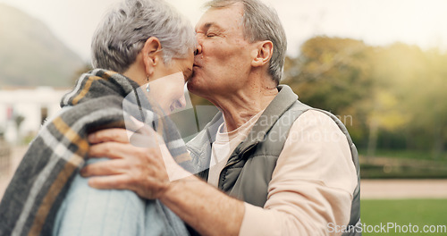 Image of Kiss, forehead and senior couple in a park with love, happy and conversation with romantic bonding. Kissing, old people and elderly man embrace woman with care, romance or soulmate connection outdoor