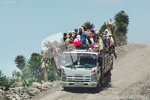 Image of People traveling dangerously on truck