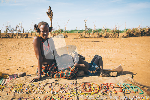 Image of Dasanesh woman offering handmade souvenirs, Omorate, Omo Valley, Ethiopia