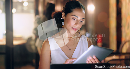 Image of Night office, tablet and business woman typing email, report or sales proposal. Overtime, technology or black female employee with touchscreen busy working late on marketing project in dark workplace