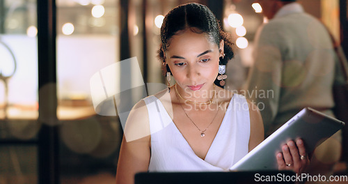Image of Night office, tablet and business woman typing email, report or sales proposal. Overtime, technology or black female employee with touchscreen busy working late on marketing project in dark workplace
