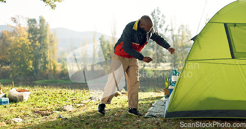 Image of Camping, tent and black man setup in nature for shelter on outdoor holiday, vacation and adventure, Campsite, traveling and male person with hammer for pins for gear in woods, forest and countryside