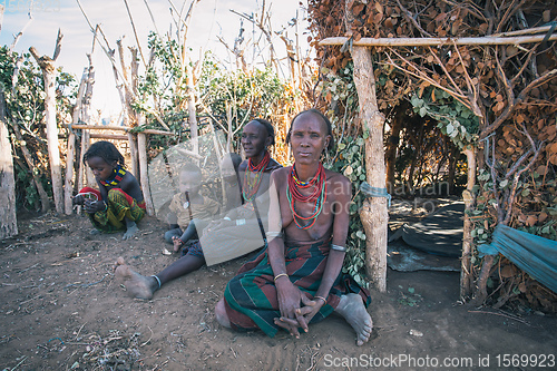 Image of Dasanesh woman with children in front of his hut. Omorate, Omo Valley, Ethiopia