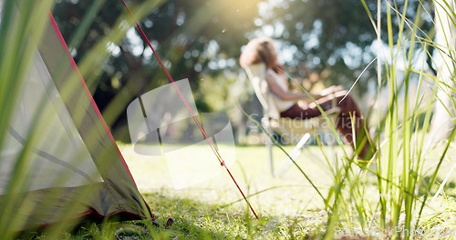 Image of Nature, camp and woman sitting in a park, forest or the woods in the morning to relax with fresh air. Calm, peace and female person with chair in an outdoor green garden on weekend trip or adventure.