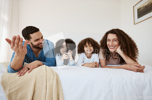 Image of Bed, happy family children and parents watching tv series, movies or online streaming service, entertainment or video. Bedroom, home and relax mother, father and kids watch show, television or film