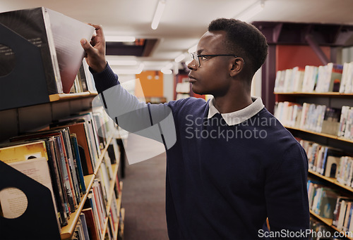 Image of University, books and black man in a library reading and learning on campus for knowledge and education in college. Smart, clever and person doing research or studying by a shelf for an exam