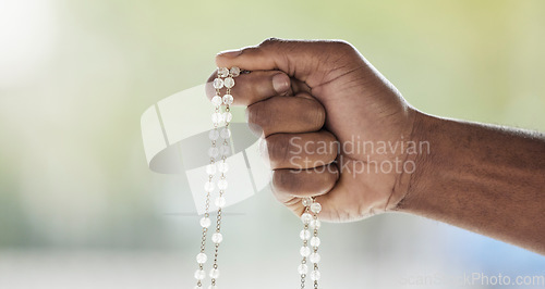 Image of Rosary, person hand and prayer beads in a home with hop, christian praise and religion. Praying, necklace and worship in a house with hope, gratitude and spiritual guide for support and healing