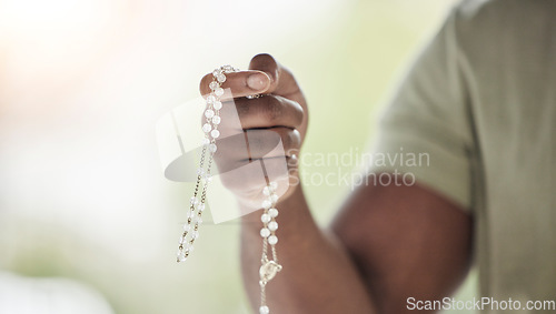 Image of Rosary, man hands and prayer beads in a home with hop, christian praise and religion. Praying, necklace and worship in a house with hope, gratitude and spiritual guide for faith support and healing