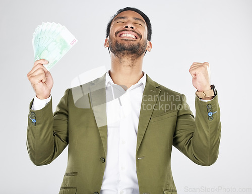 Image of Money, winner and man with fist celebration in studio for payment, loan or cashback on grey background. Cash, award and Japanese male celebrating investment, growth or financial freedom bingo prize