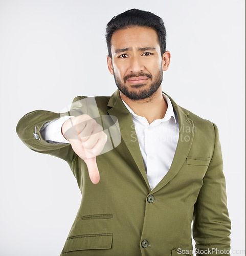 Image of Sad, portrait and man with thumbs down in studio for rejection, no or bad review on grey background. Face, frown and Japanese model with emoji finger for negative, vote or feedback fail or opinion