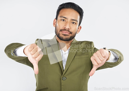 Image of Portrait, thumbs down and man in studio for wrong, vote or disagreement sign on white background. Face, rejection and Mexican male with emoji hand vote for fail, feedback or opinion, choice or review