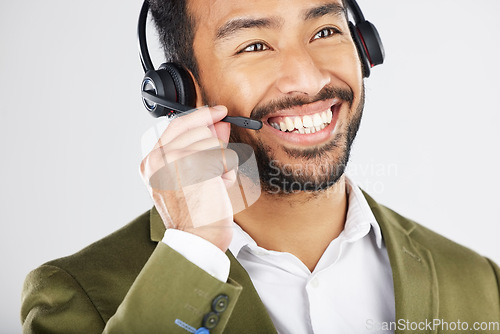 Image of Happy asian man, call center and headphones in telemarketing, customer service or support against a white studio background. Friendly businessman, consultant or agent smile in online advice or help