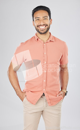 Image of Happy, fashion and portrait of Asian man in studio smile for confidence, pride and happiness. Confident, attractive and isolated person in casual style, trendy clothes and outfit on white background