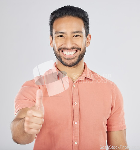 Image of Happy asian man, portrait and thumbs up in good job, winning or success against a white studio background. Male person smile with like emoji, yes sign or OK in agreement, thank you or approval
