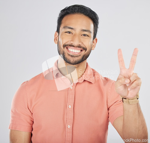 Image of Portrait, smile and asian man with peace hands in studio for thank you, support or feedback on grey background. V, emoji and face of happy Japanese guy model with feedback, opinion or positive review