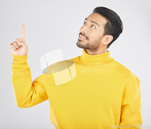 Image of Announcement, thinking and man pointing for promotion, deal and logo isolated in a studio white background with smile. Choice, offer and happy person or ambassador showing advertising or news