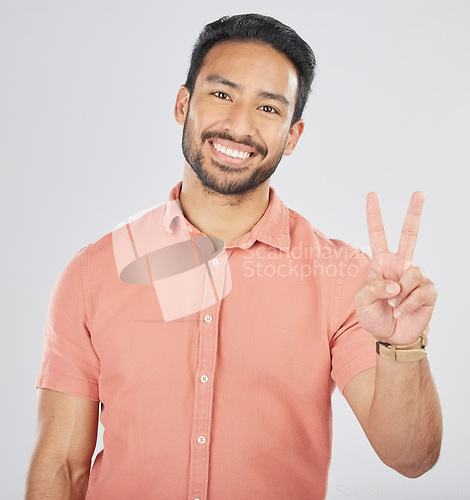 Image of Peace, hands and portrait of happy man in studio for thank you, vote or feedback on grey background. V, sign and Japanese guy face with good vibes, smile or freedom emoji, support or self love