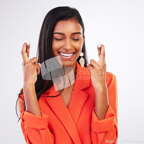 Image of Face, smile and woman with fingers crossed in studio for good luck, hope or wish on white background. Happy, excited and female model with optimistic hand emoji review ,feedback or waiting for news