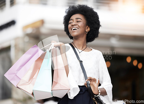 Image of Shopping bag, happy customer and black woman walking outdoor in a city for retail deal, sale or promotion. African person with a smile or excited about buying fashion commerce product on urban travel