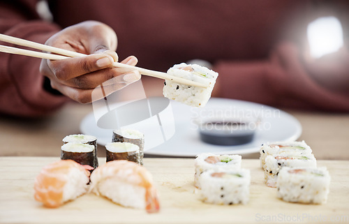 Image of Sushi, seafood and restaurant with hands of person in store for brunch, Japanese cuisine and menu. Fish, salmon and health with closeup of customer eating for nutrition, Asian diet and fine dining