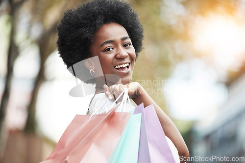 Image of Woman, shopping bag and portrait of a happy customer outdoor in a city for retail deal, sale or promotion. African person with a smile and excited about buying fashion product in urban travel space