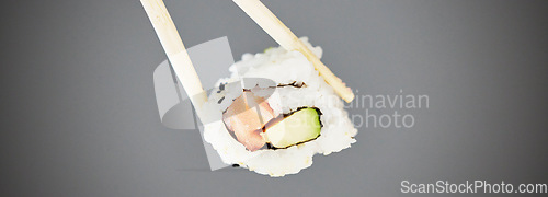 Image of Seafood, sushi and chopsticks in studio, salmon roll isolated for healthy Asian dining promo. Japanese food culture with rice, raw fish and avocado, restaurant menu offer or deal on grey background.