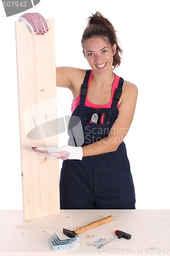 Image of woman carpenter holding wooden plank 