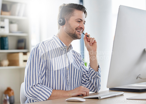 Image of Happy, customer service and consultant or man in call center speaking online for technical support, advice or help. Employee, talking and consulting person in London working in crm for tech startup