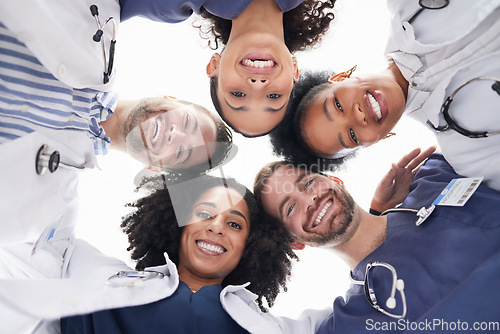 Image of Happy people, portrait and doctors in huddle, teamwork or unity in healthcare mission together below. Low angle of excited group of medical professionals smile in team building, support or goals